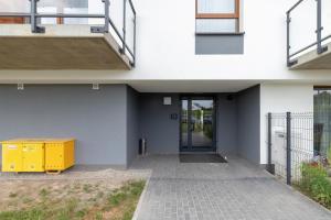 a white building with a door and a yellow box at Apartments Św. Brata Alberta by Renters in Gdańsk