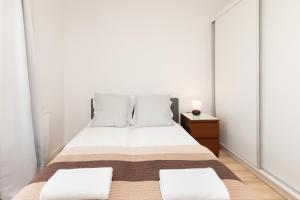 A bed or beds in a room at Apartments Św. Brata Alberta by Renters