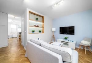 Biały salon z kanapą i telewizorem w obiekcie Jacht Marina Gdynia w mieście Gdynia