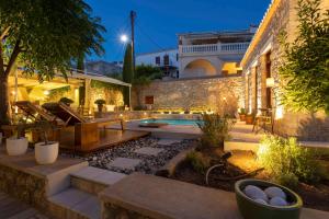 un patio con piscina y un edificio en Mare Monte Luxury Suites en Spétses