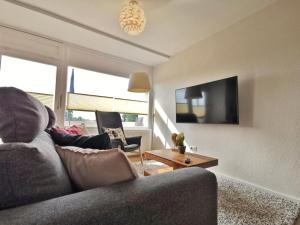 a living room with a couch and a tv at Ferienwohnung Ebbe & Flut in Horumersiel