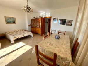 a living room with a table and a bed at Le Residenze di Dolores - On Citara Beach in Ischia