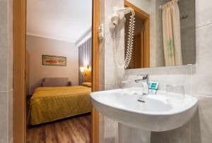 a bathroom with a sink, mirror, and bathtub at Hotel Lyon in Barcelona