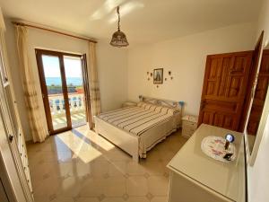a bedroom with a bed and a large window at Le Residenze di Dolores - On Citara Beach in Ischia