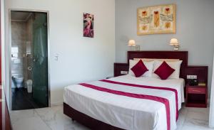 a bedroom with a large bed with red pillows at Hotel Villa Nisteri in Limenas