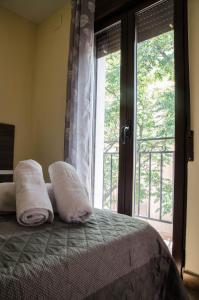 um quarto com uma cama com duas almofadas e uma janela em La Casita de la Plaza em Granada