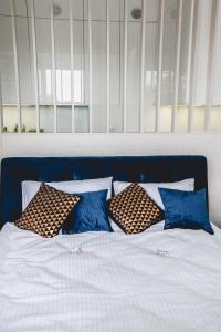 uma cama com almofadas azuis e brancas em Hypnotize Apartment Glamour em Konin