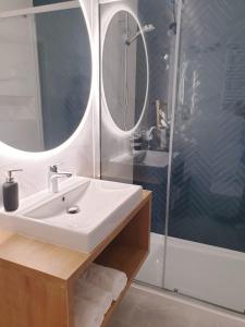 a bathroom with a sink and a shower at Albus 112 ApartPark in Świnoujście