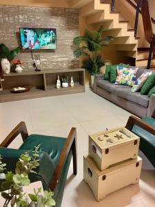 ein Wohnzimmer mit einem Sofa und einem TV in der Unterkunft Casa Perfeita para suas férias in Salinópolis