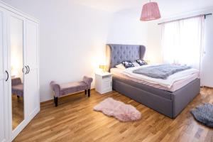 ein Schlafzimmer mit einem Bett, einem Stuhl und einem Spiegel in der Unterkunft Silvie Apartments - Zlaté Terasy in Olomouc