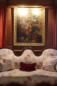 a couch with a painting of flowers in a room at Solar De La Plaza in Salta