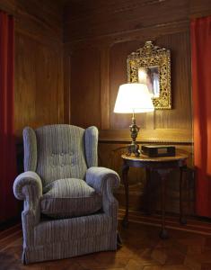 a room with a chair and a table with a lamp at Solar De La Plaza in Salta