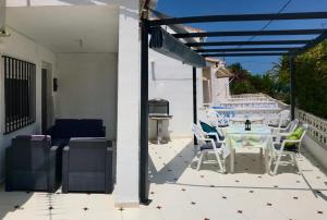 a patio with a table and chairs on a house at Adosado de 140m2 con terraza a 50 m de la playa in Denia