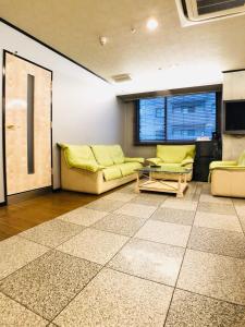 a living room with two couches and a window at Hotel Ritz Koshien in Nishinomiya