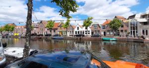 een rivier met huizen en boten in een stad bij Oudegracht Alkmaar in Alkmaar