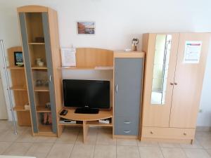 a room with a desk with a television and a cabinet at Apartments Tonka in Mošćenička Draga