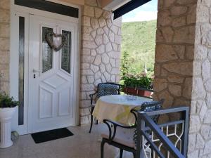 a door to a patio with a table and chairs at Apartments Tonka in Mošćenička Draga