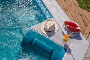 a hat and a drink on a table next to a pool at The Wave in Sidari