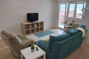 a living room with a blue couch and two chairs at Mundaka Sea & Mountain Views. Wifi, Parking in Mundaka