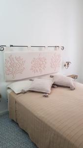 ラ・マッダレーナにあるBilocale Milùのベッドルーム(白いヘッドボード付きの大型ベッド1台付)
