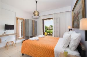 ein Schlafzimmer mit einem großen Bett mit orangefarbenen und weißen Kissen in der Unterkunft The Wave in Sidari