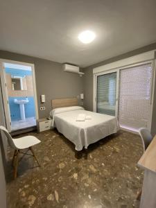 um quarto com uma cama e uma casa de banho com um lavatório em AYAMONTE ROOMS 43 em Ayamonte