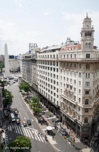 a large white building on a city street with traffic at HR Luxor Hotel Buenos Aires in Buenos Aires
