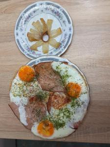two plates of food on a wooden table at Thomas Apartman Eger in Eger