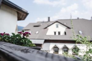 un balcón con flores y vistas a una casa en Toschis Station-Motel-Wirtshaus-an der Autobahn-Bowling, en Zella-Mehlis