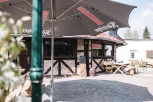 a black umbrella sitting in front of a restaurant at Toschis Station-Motel-Wirtshaus-an der Autobahn-Bowling in Zella-Mehlis