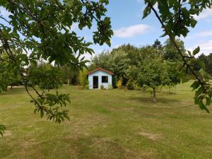 a small white house in a field with trees at L' Albizia in Pintheville