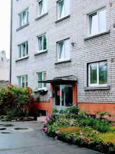 a brick building with flowers in front of it at Liudmila in Liepāja +5 photos