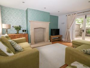 a living room with two couches and a fireplace at Limers Cottage in Buxton