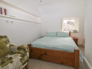 a bedroom with a bed and a couch and a window at Limers Cottage in Buxton
