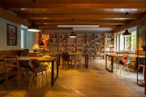 a library with tables and chairs and bookshelves at Hostel Szczelinka in Pasterka