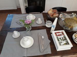 a table with white plates and a vase of flowers at Contrada Zerbate in Aci SantʼAntonio