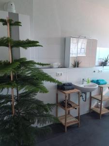 een badkamer met een kerstboom en een wastafel bij Ferienwohnung am Kiessee in Breitungen