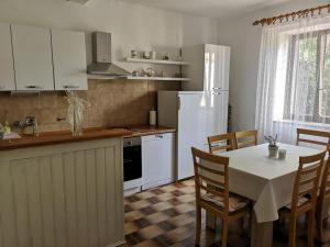cocina con mesa y nevera blanca en Apartment Kalavojna, en Rakalj