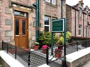 a street sign in front of a building with a sign at Carisbrooke Guest House in Inverness