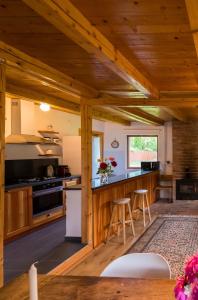 una cocina con armarios de madera y una barra con taburetes en Chalet M en Lunca Bradului