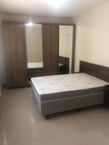 Un dormitorio con una cama y un espejo grande. en Apto Piratuba Termas, en Piratuba
