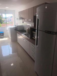 Una cocina con refrigerador de acero inoxidable y estufa. en Apto Piratuba Termas, en Piratuba