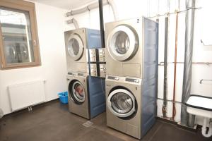 two washing machines and a washer and dryer in a room at Campus Apartments in Göttingen