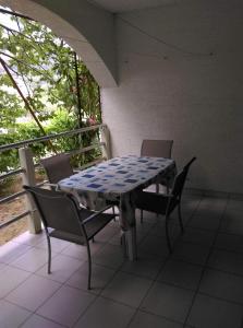 una mesa y sillas sentadas en un balcón en Apartmani Vrzić, en Baška