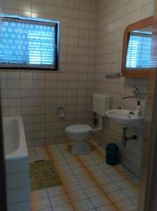 y baño con aseo y lavamanos. en Apartmani Vrzić, en Baška
