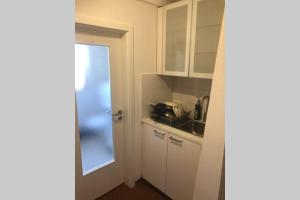 a small kitchen with white cabinets and a sink at historisches Fachwerkhaus in Alzenau