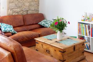 sala de estar con sofá y mesa con un jarrón de flores en Abitarela - Maison d'Hôtes - B&B en Sigean