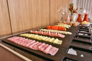 a buffet line with different types of cheese and meats at Hotel Fernandópolis in Fernandópolis +51 photos