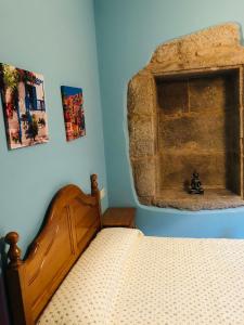a bedroom with a bed and a stone fireplace at Santiaguiño 2 in Padrón