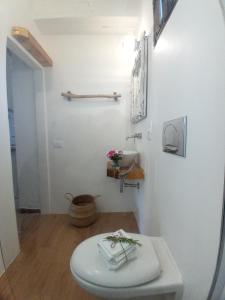 a white bathroom with a toilet and a sink at Deppy Cottage in Porto Columbu - Perdʼe Sali
